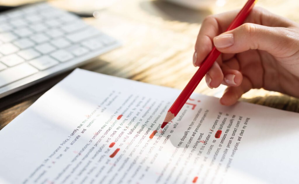 Professional editor making corrections on a printed manuscript with a red pen, ensuring accuracy and clarity.